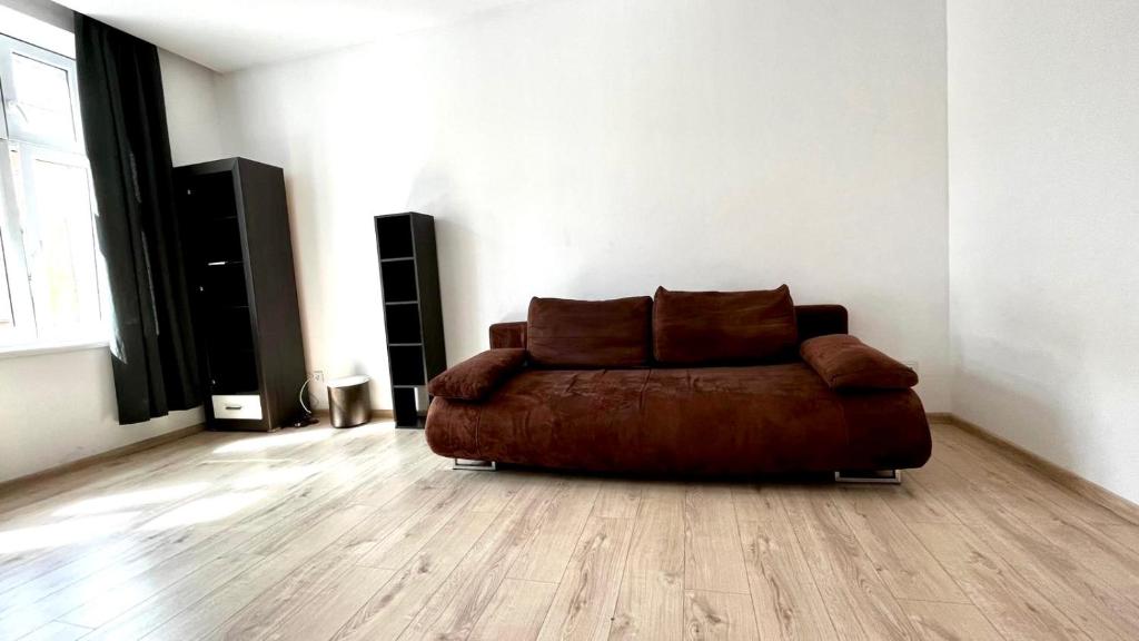 a brown couch in a living room with wooden floors at Felicjanek Apartment in Krakow