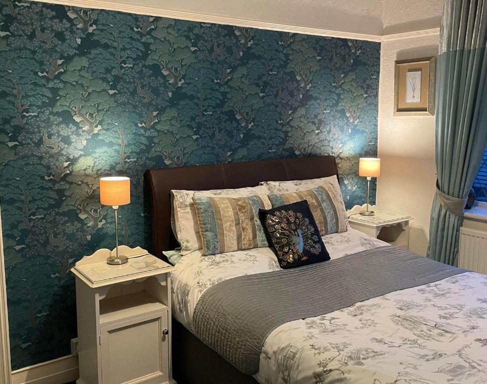 um quarto com uma cama e uma parede verde em EsJays at Knowles House em Lytham St Annes