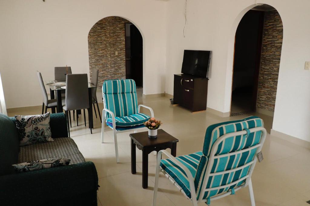 a living room with a couch and chairs and a table at Genesis Hospedaje Yopal in Yopal