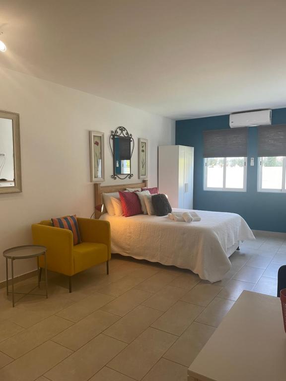 um quarto com uma cama e uma cadeira amarela em Bayview Apartment 213 em Albufeira