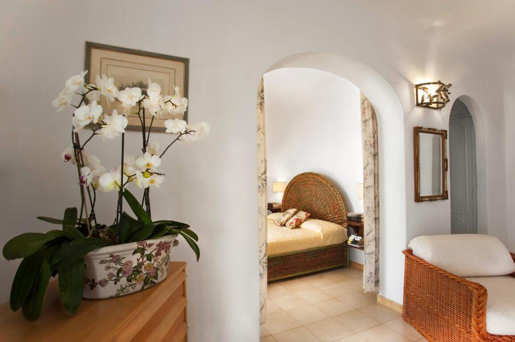uma sala de estar com um vaso de flores sobre uma mesa em Residence Palummera em Ischia