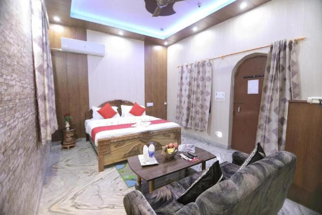 アグラにあるHotel Reshmi In Agra Near Chandrashekhar Park - Best Locationのリビングルーム(ベッド1台、ソファ付)