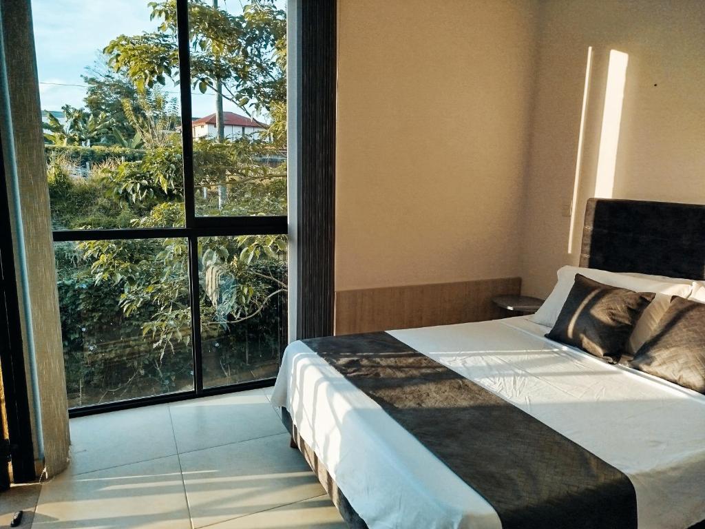 1 dormitorio con cama y ventana grande en Apartamento armenia, en La Tebaida