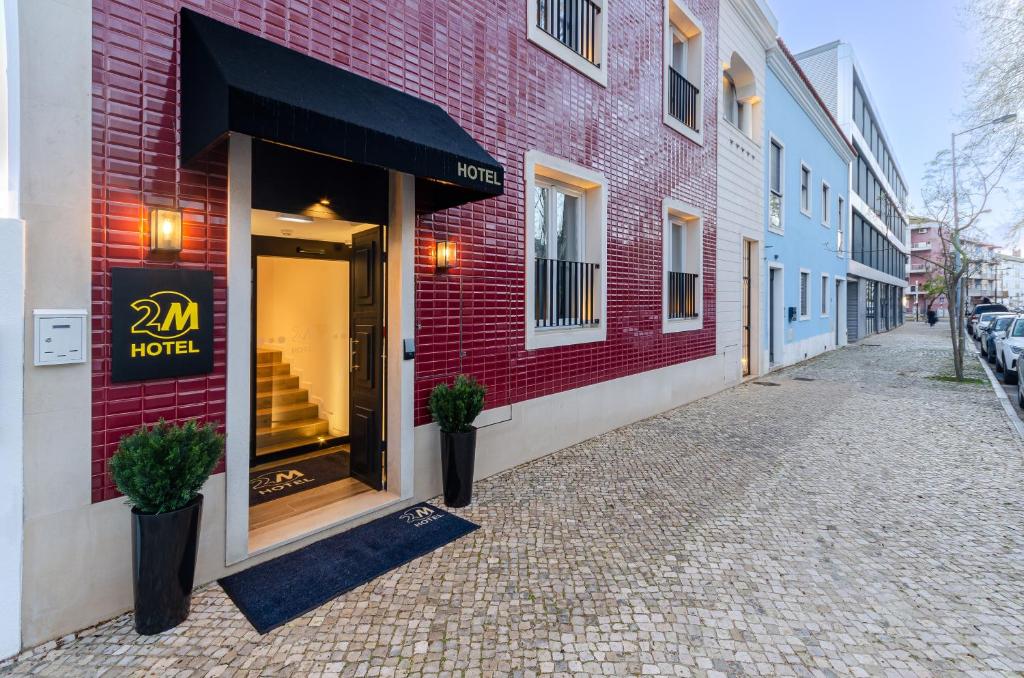 un bâtiment en briques rouges avec une fenêtre de magasin dans une rue dans l'établissement 2M BOUTIQUE HOTEL, à Montijo