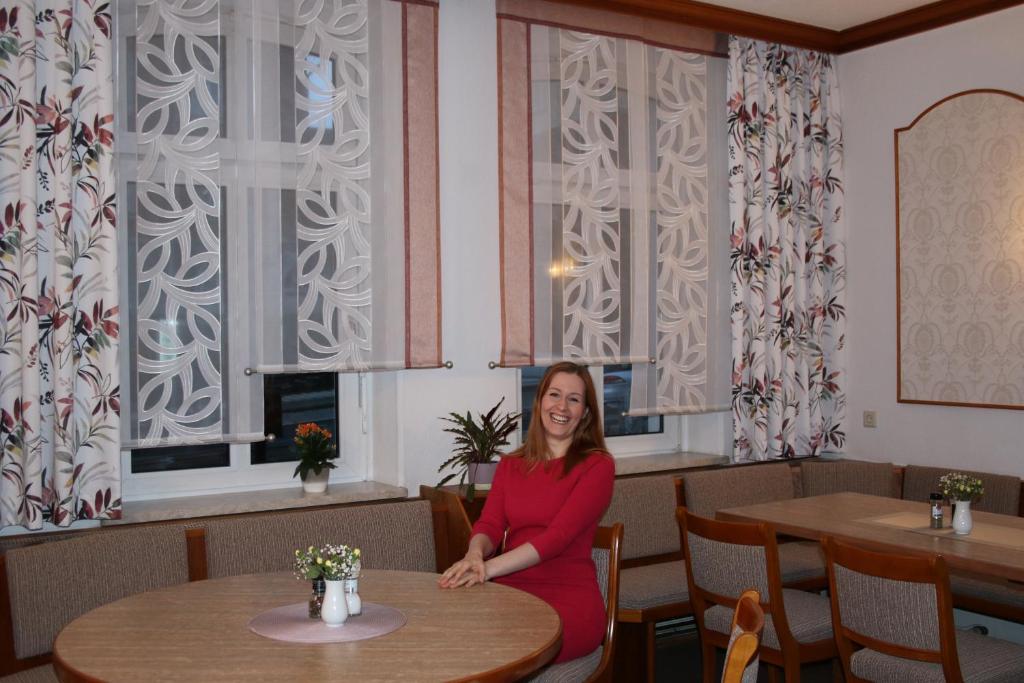 a woman sitting at a table in a restaurant at Pension Erholung in Bad Elster