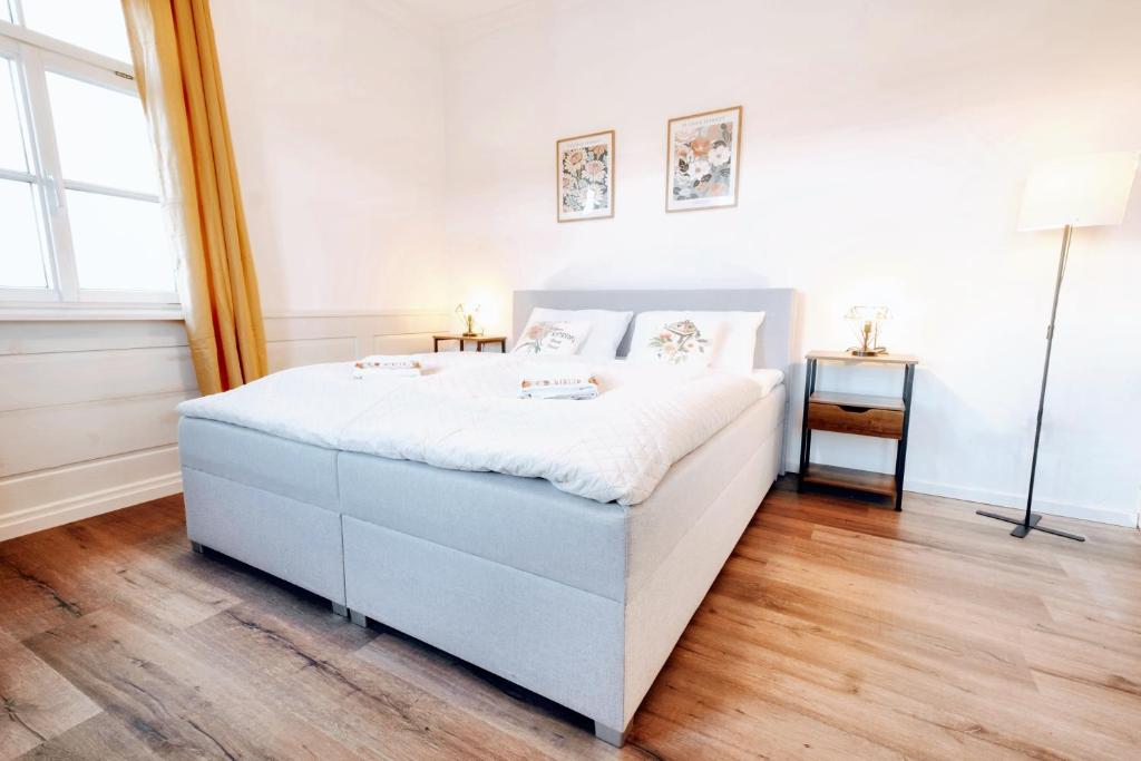 a white bedroom with a large bed and a window at BackHome - Fantastische Schlosslage, SmartTV, Waschtrockner, Netflix, 50qm, 24h Checkin - Apartment 3 in Ludwigsburg