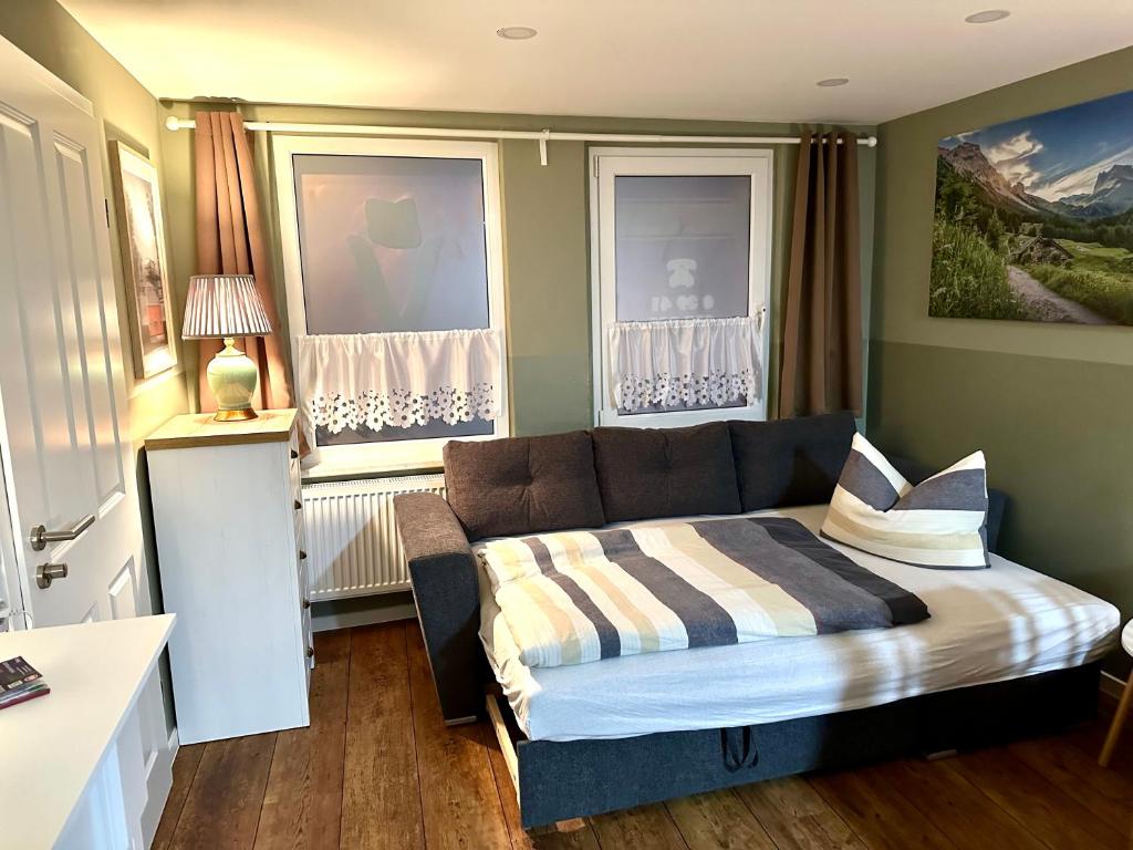 ein Wohnzimmer mit einem Sofa und einem Bett in der Unterkunft Pension Victoria in Halberstadt