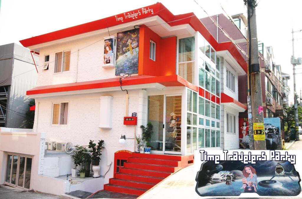una casa con una escalera roja delante de ella en Time Travelers Party Hostel In Hongdae, en Seúl