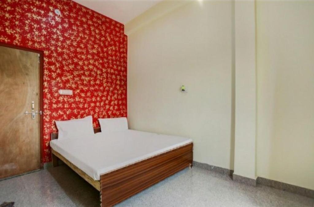 a bed in a room with a red wall at Goroomgo Hotel M J Agra Near Taj Mahal 950m in Agra