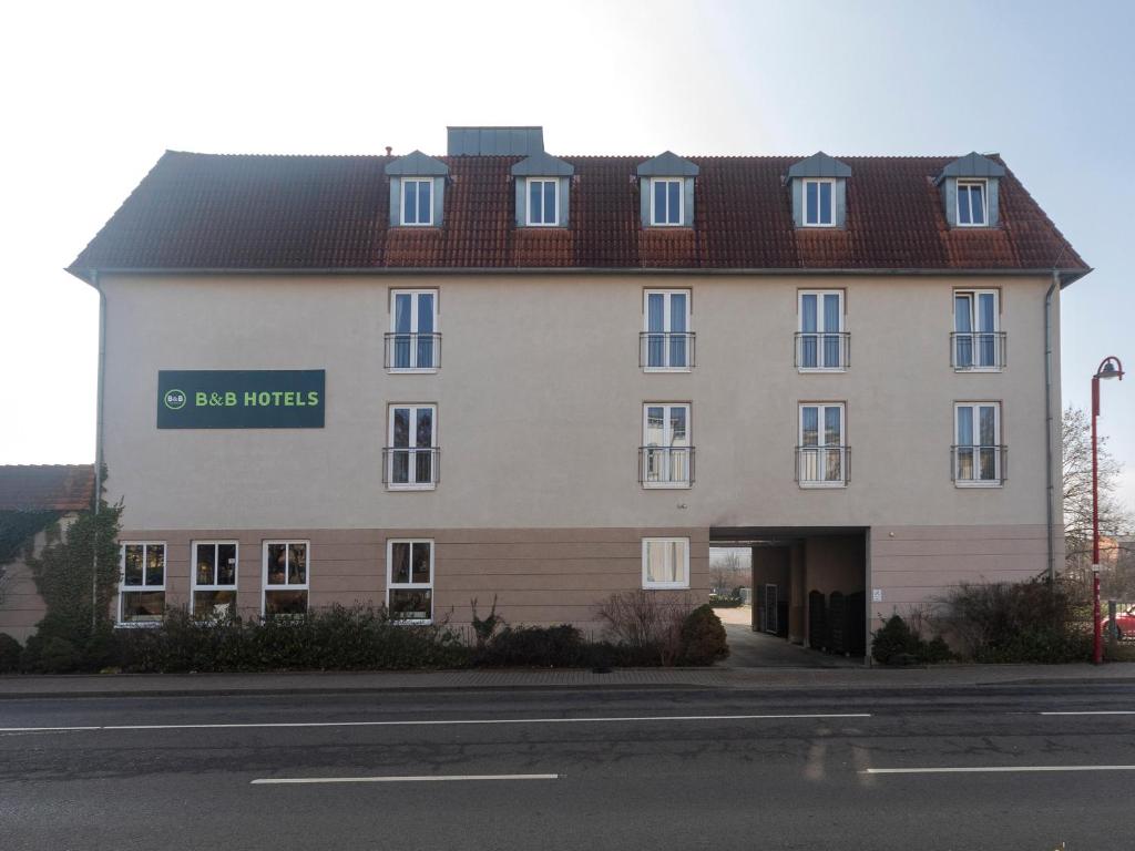 ein großes weißes Gebäude mit einem Schild drauf in der Unterkunft B&B HOTEL Gotha-Hbf in Gotha