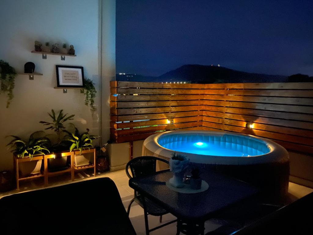 une chambre avec un bain à remous sur un balcon la nuit dans l'établissement Marvinas seaside apartments, Earth apartment & Ocean jacuzzi apartment, à Kremasti