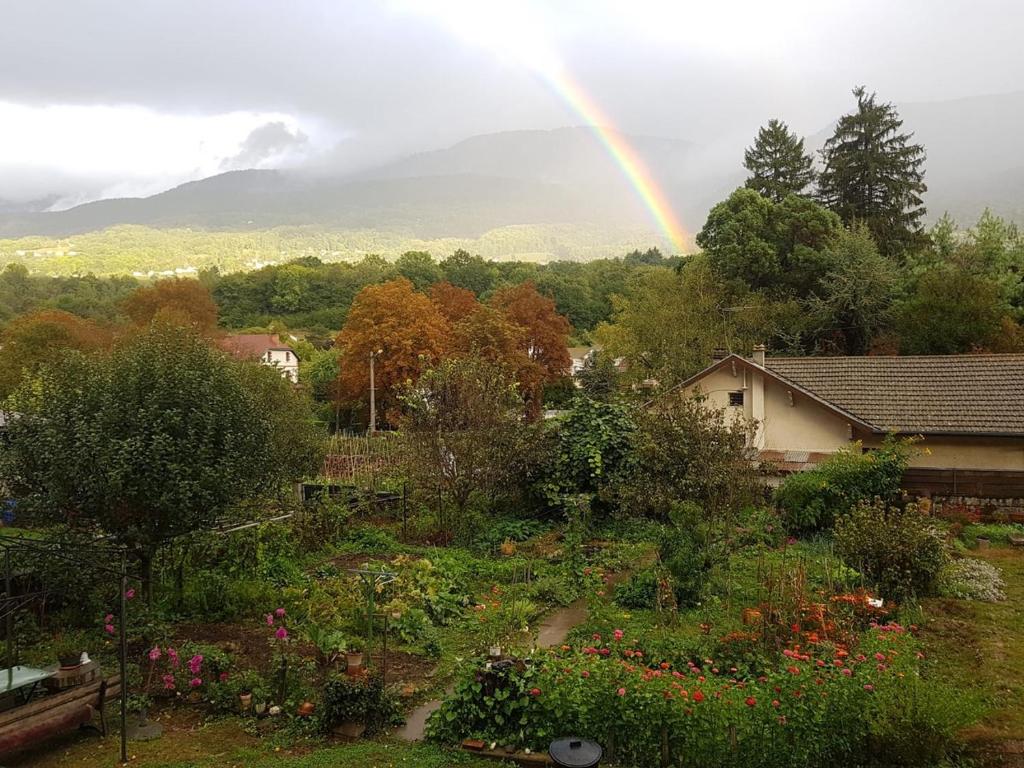 a rainbow in the sky over a garden at Appartement à Uriage les Bains. in Vaulnaveys-le-Haut