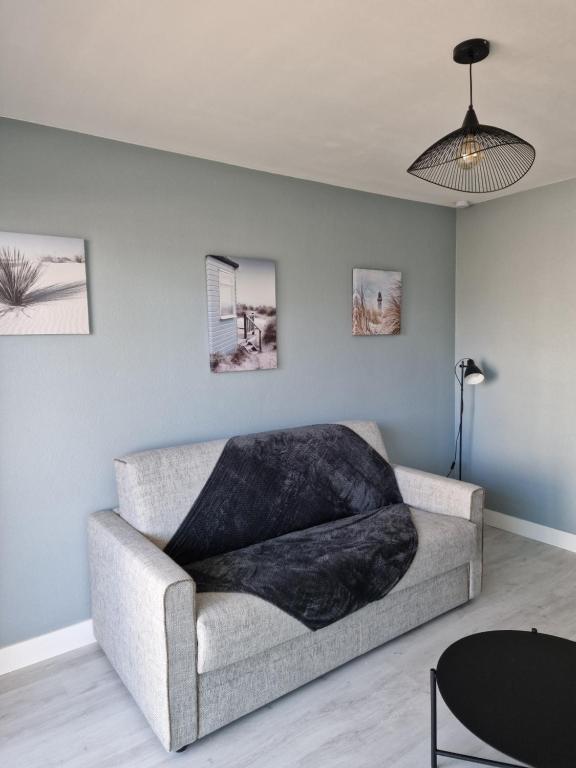 un salon avec un canapé et une table dans l'établissement Studio vue mer, à La Baule