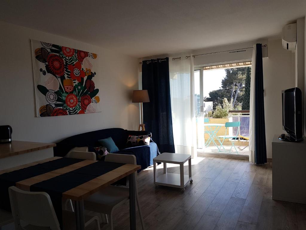 un salon avec un canapé et une table dans l'établissement Grand T2, 4 personnes, Clim, Parking, Proche centre, à Sanary-sur-Mer