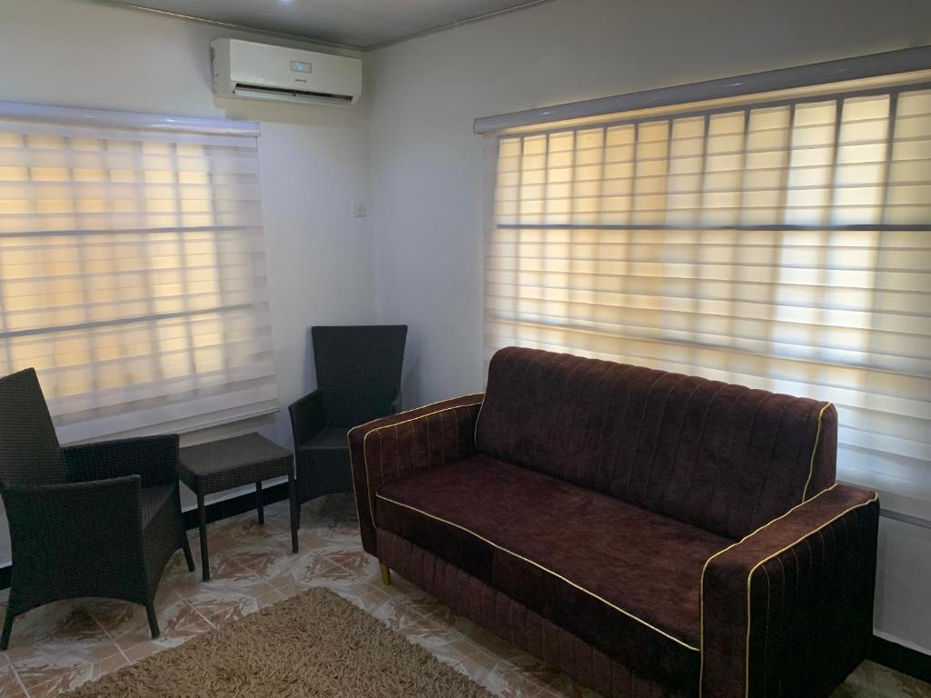 a living room with a couch and two chairs at Adel’s Place in Abuja