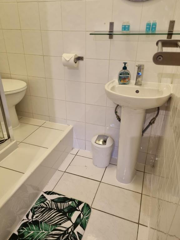 a white bathroom with a sink and a toilet at The Windmill Hotel in London