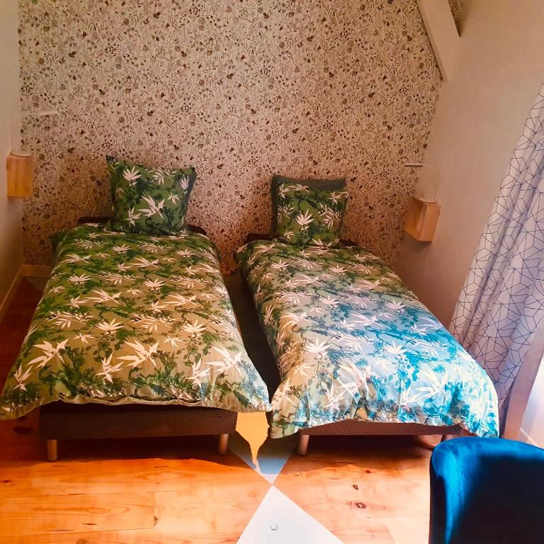 two beds sitting next to each other in a room at Chambres d&#39;Hôtes du Domaine de Bourbacoup in Tulle