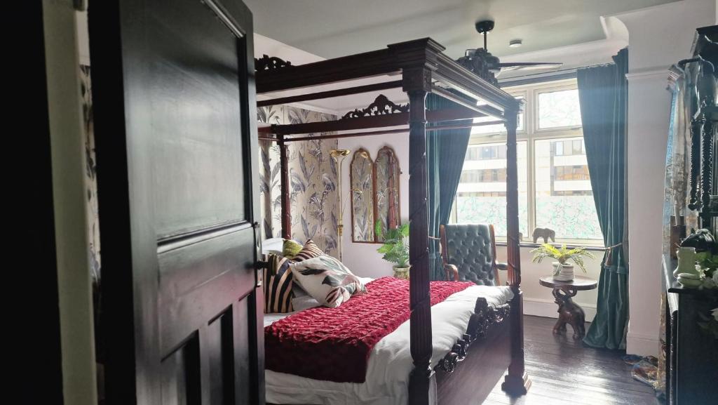 a bedroom with a canopy bed and a window at Flawsome stays Unique Edwardian Home near the Harbour and town perfect for Families up to 8 guests in Ramsgate