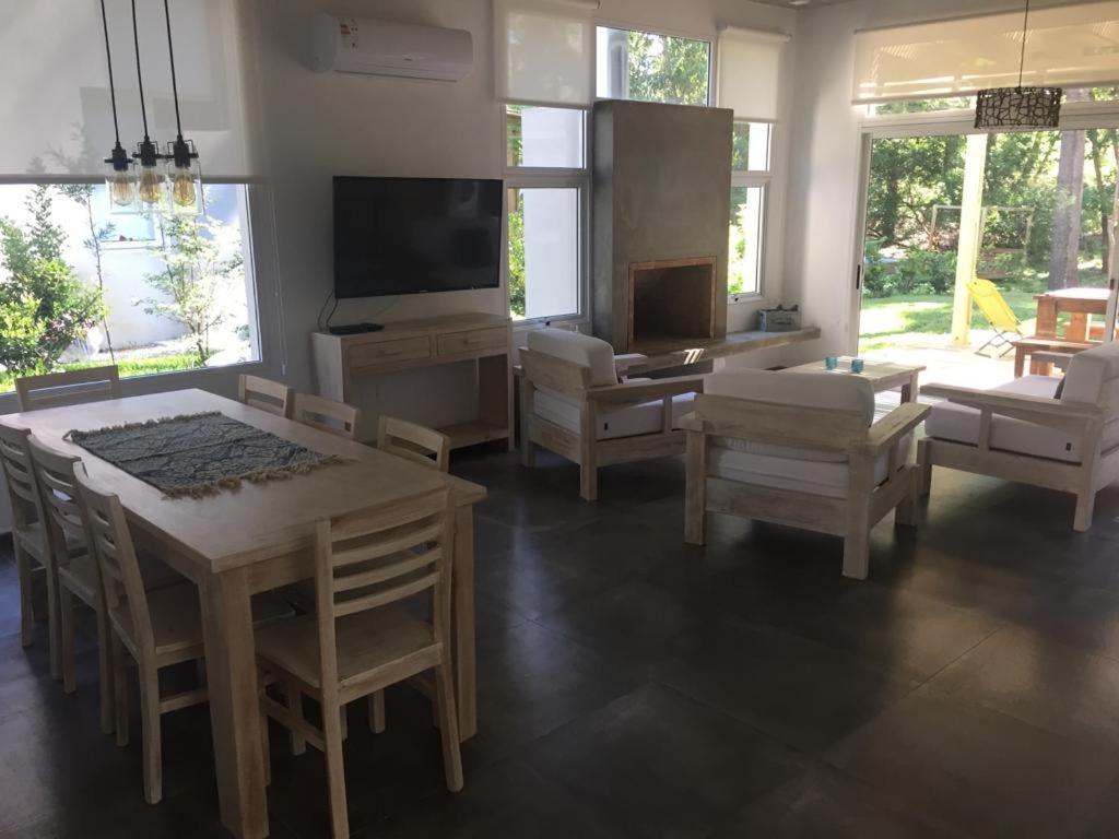 uma sala de estar com uma mesa e cadeiras e uma televisão em Excepcional Casa en Solanas Resort em Punta del Este