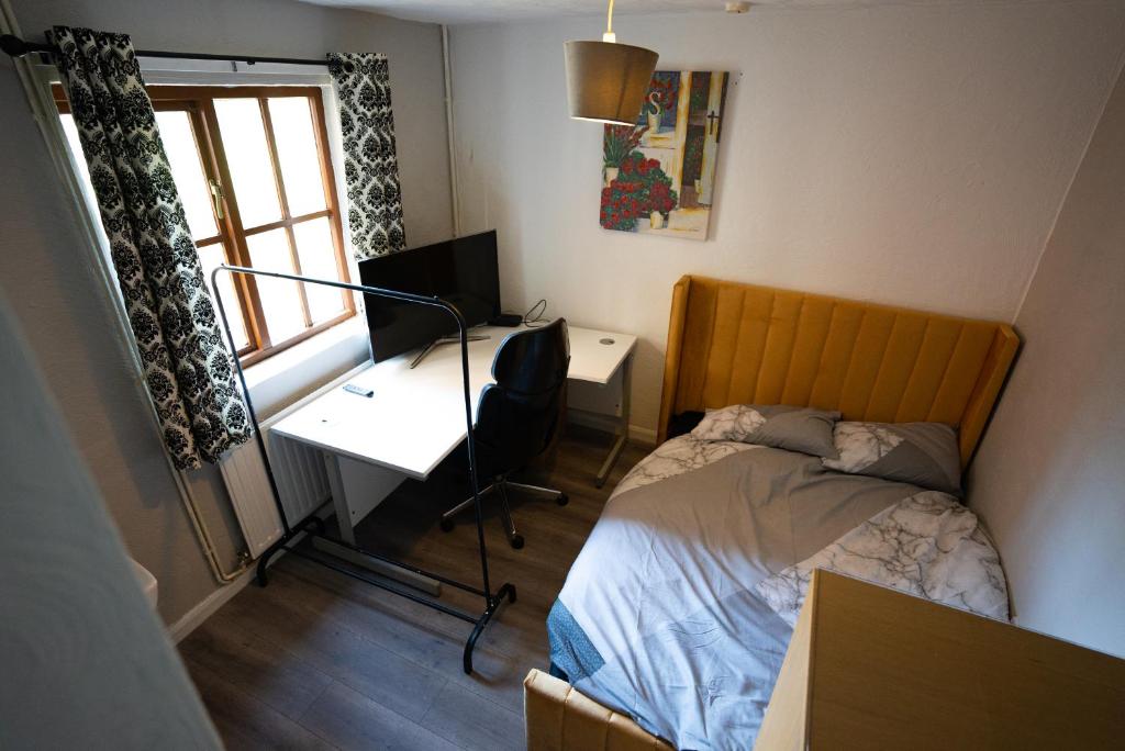 1 dormitorio con 1 cama y escritorio con escritorio en Sevenoaks Guest House, en Trimley Heath