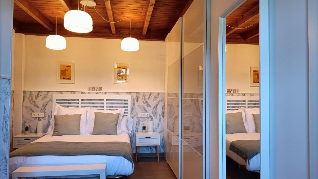two beds in a room with sliding glass doors at Zarraci La Guía in Gijón