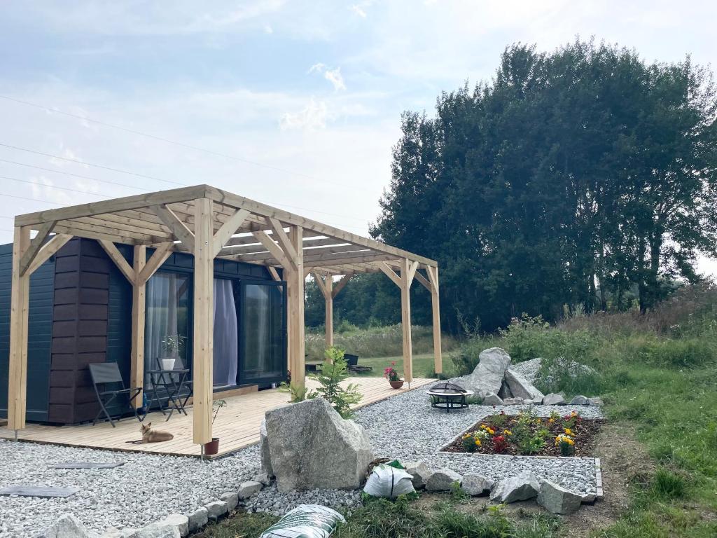una piccola cabina con una terrazza in legno e alcune rocce di Tiny House with Mountain Views a Turany