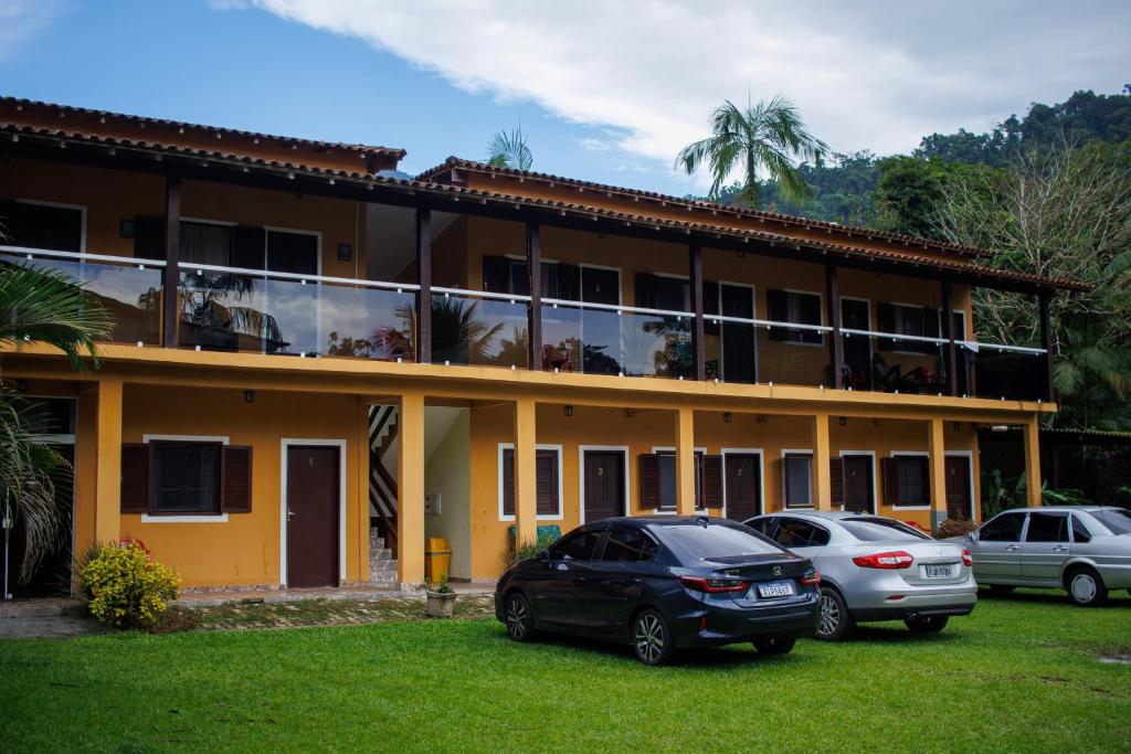 dois carros estacionados em frente a um edifício em Pousada cachoeira de Paraty em Sertão do Taquari