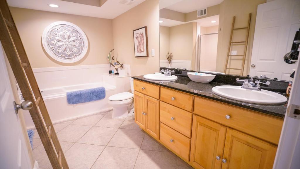 a bathroom with two sinks and a toilet at NEW-The Villas-Pool-BBQ-Casino-Colosseum-Beach-Tennis Courts in Biloxi