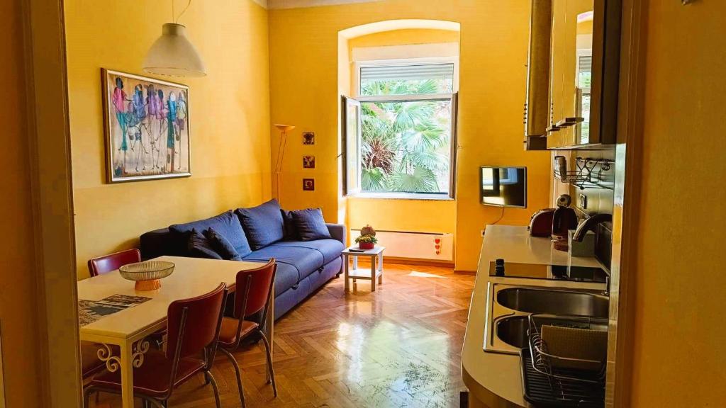 a living room with a blue couch and a table at Apartment Colors of Life in Rijeka