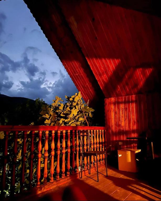 un techo rojo de una casa con una silla en un porche en Buba, en Oni