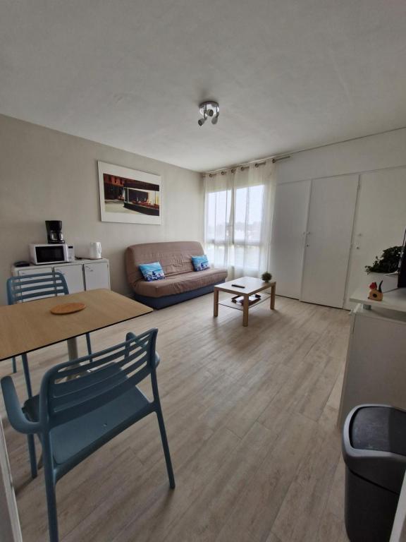 - un salon avec une table et un canapé dans l'établissement Studio - Pleine Mer - 1 avenue des Pays de Monts - 1-1, à Saint-Jean-de-Monts