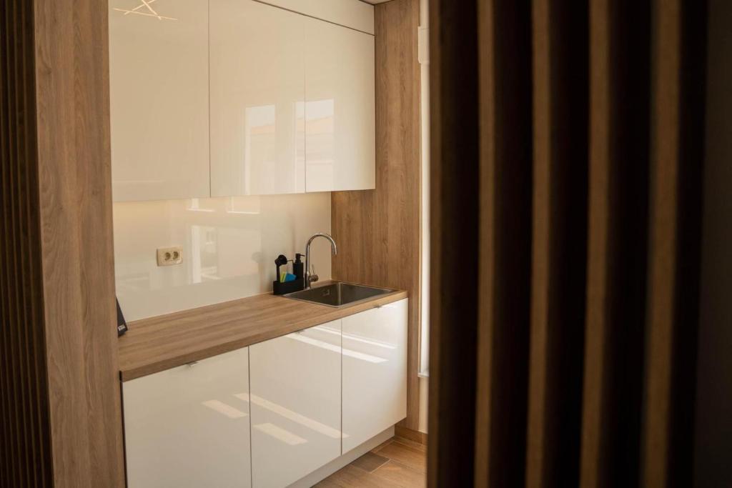 a kitchen with white cabinets and a sink at Luxury and Spa App F in Makarska