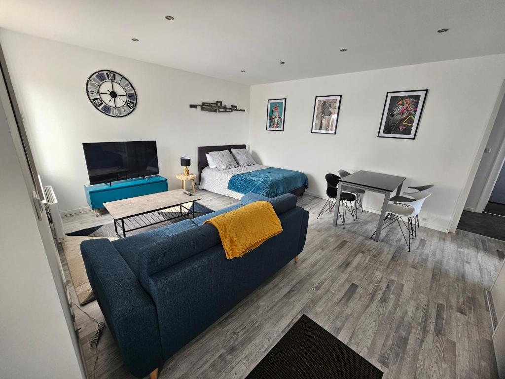 - un salon avec un canapé bleu et un lit dans l'établissement F2 neuf tout confort proche Epinal/ lac de Bouzey, à Uxegney