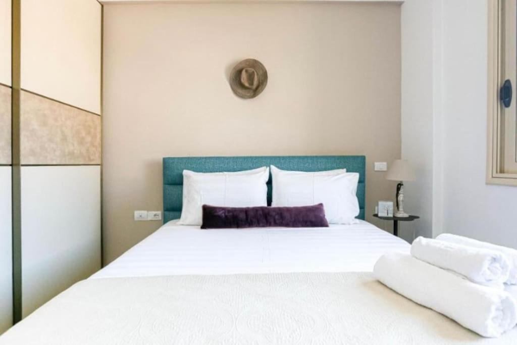 a bedroom with a large white bed with a blue headboard at Luxury Suite 3 in Himara in Himare