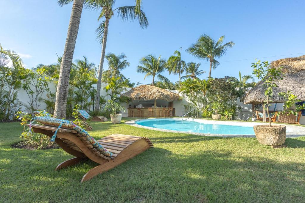 ein Resort mit einem Pool und einem Stuhl im Gras in der Unterkunft Surf Salvacion in San Felipe de Puerto Plata