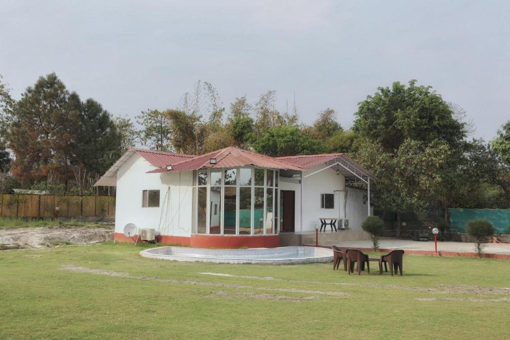 a small white house with a table in a yard at RAHA FARM in Noida