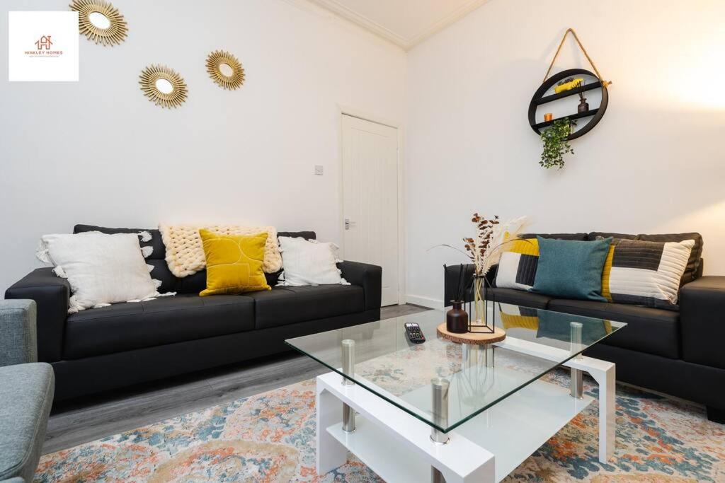 sala de estar con 2 sofás negros y mesa de cristal en Large 3 bedroom sleeps-7/Gartson/Liverpool, en Liverpool