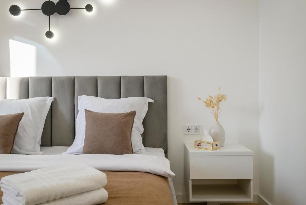 um quarto com uma cama com uma cabeceira cinzenta em 5 NEW BUSINESS-CLASS APARTMENTS R-HOUSE near MEGA em Almaty