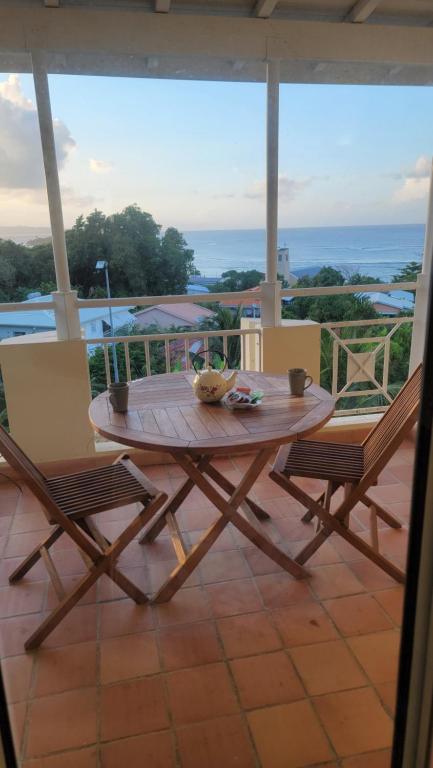 d'une table en bois et de deux chaises sur un balcon. dans l'établissement Studio vue mer - Tartane, à La Trinité
