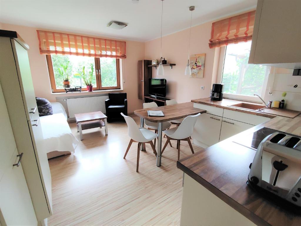 eine Küche und ein Wohnzimmer mit einem Tisch und Stühlen in der Unterkunft BodenSEE Apartments Daisendorf nahe Meersburg in Daisendorf