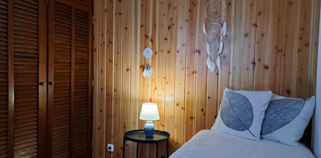 - une chambre avec un lit et un mur en bois dans l'établissement Apartamentos Casa da Travessa RENEWED, à Horta