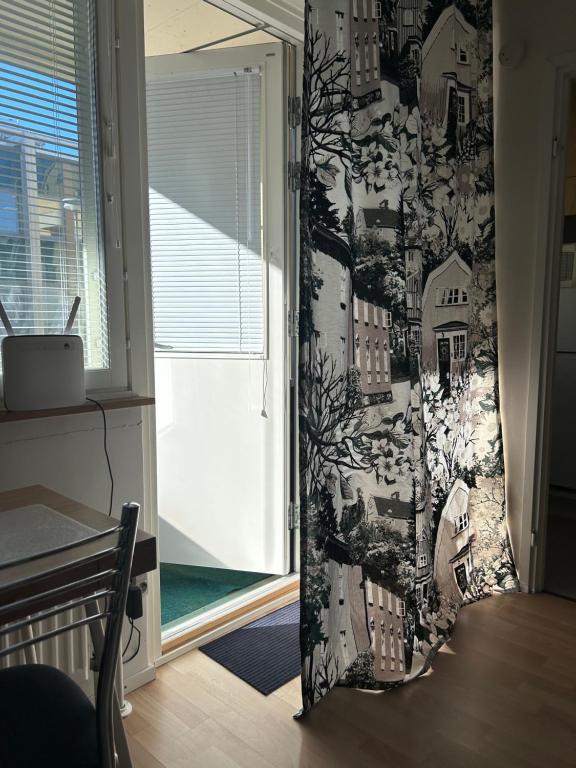 a room with a curtain that has a drawing of houses at Kuninkaankatu Apartment - Free Parking in Kuopio