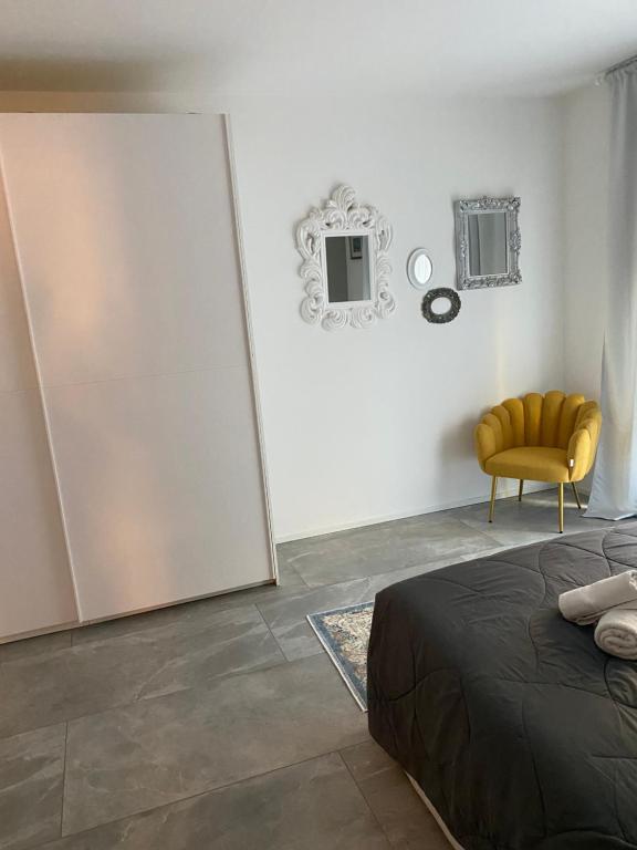 ein Schlafzimmer mit einem Bett und einem gelben Stuhl in der Unterkunft Villa Romantika in Arco