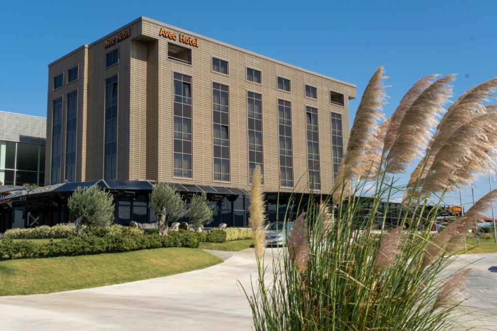 un edificio de hotel con una palmera delante de él en Avec Hotel en Çanakkale