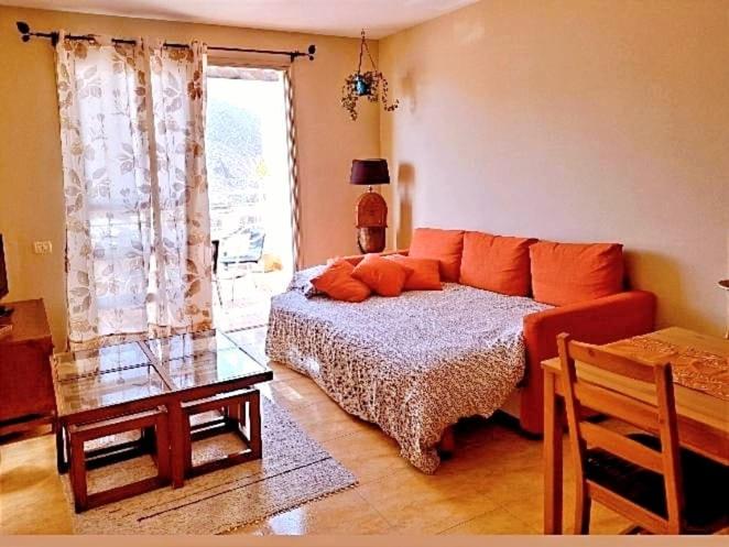 a bedroom with a bed and a table and a window at El balcón de Colon in San Sebastián de la Gomera