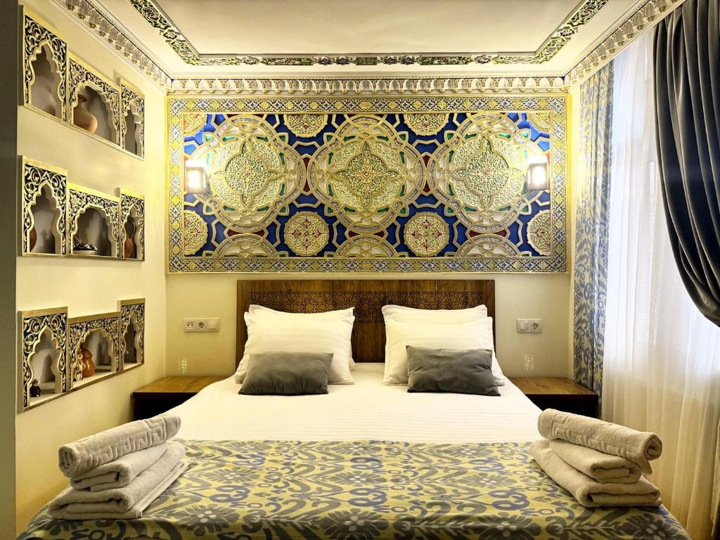 una camera con un letto con una parete blu e dorata di Bobosh Boutique a Bukhara