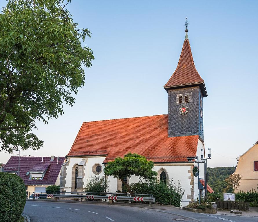 eine Kirche mit einem Uhrturm auf einer Straße in der Unterkunft Kleines Appartement Gut und Preiswert in Stuttgart