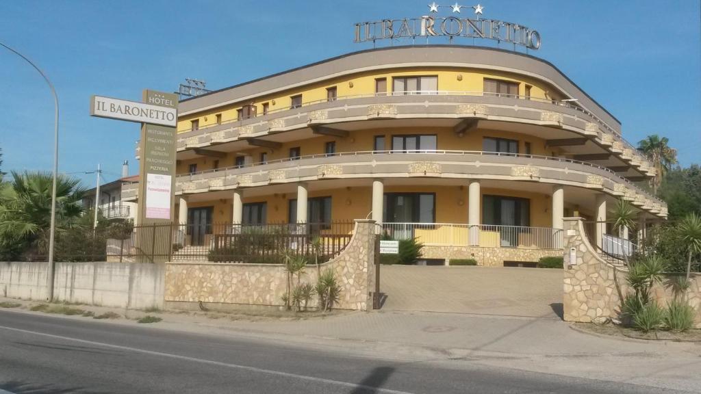 un bâtiment jaune avec un panneau en haut dans l'établissement Hotel Il Baronetto, à Tarsia