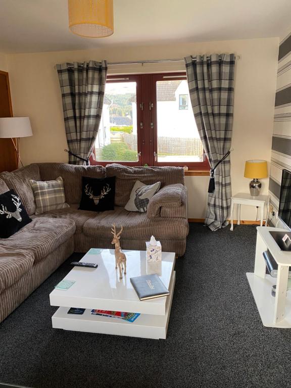 a living room with a couch and a table at Cameron apartment Loch Ness in Fort Augustus