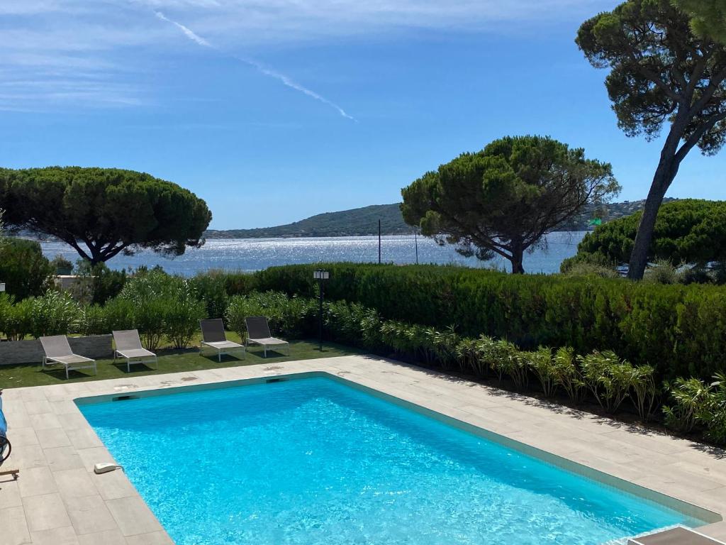 une piscine avec vue sur l'eau dans l'établissement Villa Kate, Villa moderne, 5 ch. accès privé à la plage, à Grimaud
